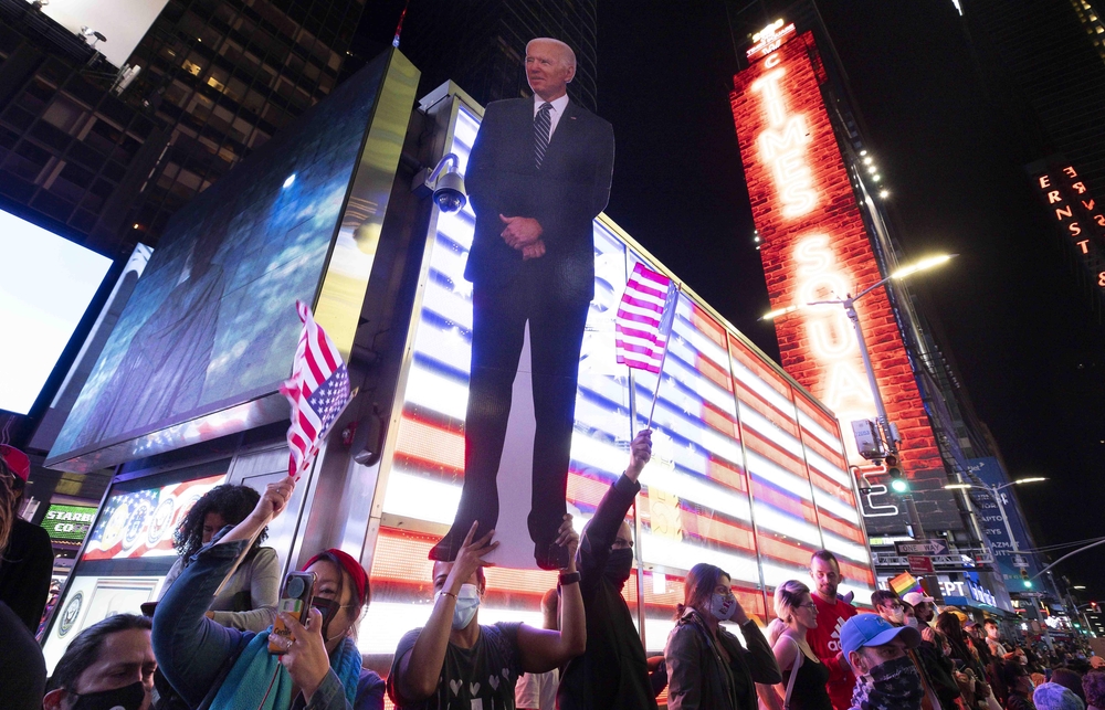People watch US President-elect Joe Biden's speech in Time Square  / JUSTIN LANE