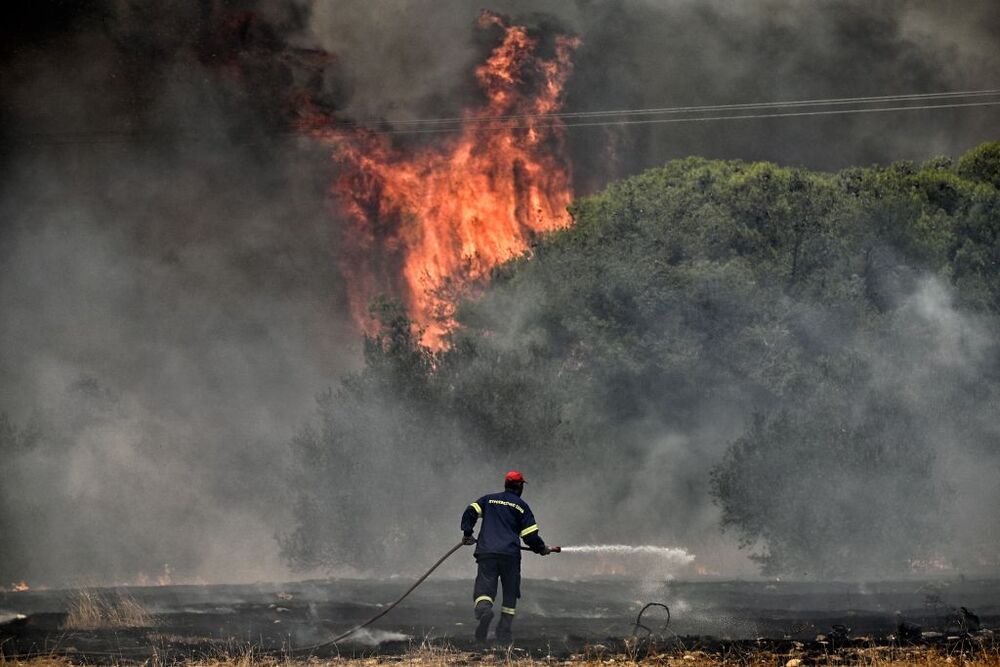 Wildfires lead to evacuations in Greece  / VASILIS PSOMAS