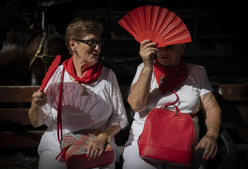 Dos mujeres alivian con abanicos el calor este lunes en Pamplona