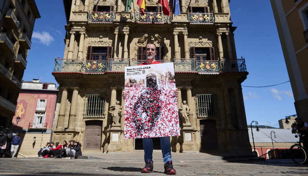 Ángel Blanco posa con el cartel en el balcón del Ayuntamiento